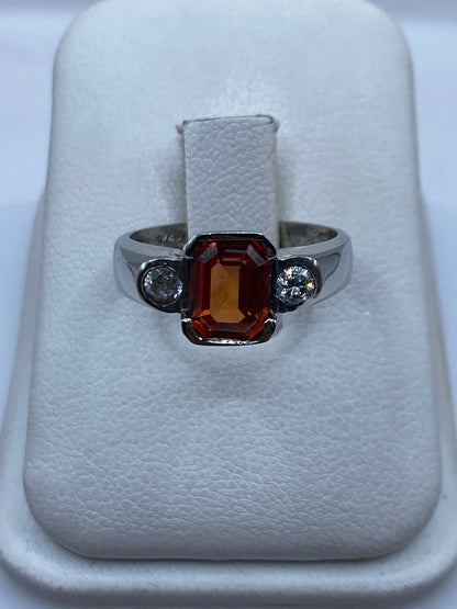 Anillo de plata solitario con circonia ámbar en caja blanca mostrando el frente
