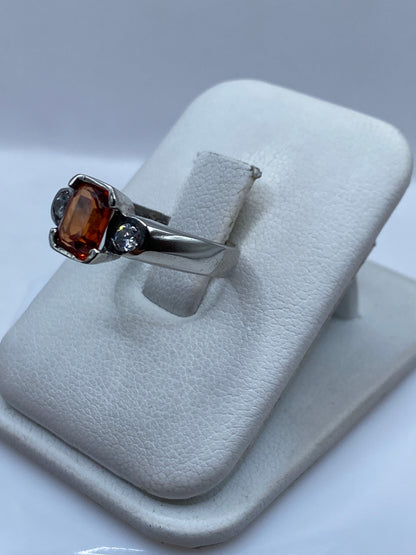 Anillo solitario de plata .925 en la mano de una mujer, circonia ámbar brillante