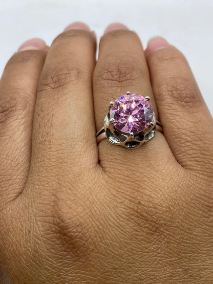 Anillo de plata solitario en dedo femenino, mostrando el brillo rosa natural de la circonia
