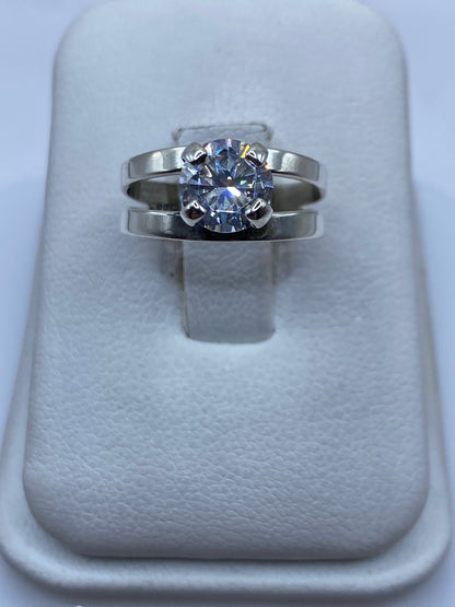 Anillo solitario de plata con circonia blanca brillante en la mano de una mujer