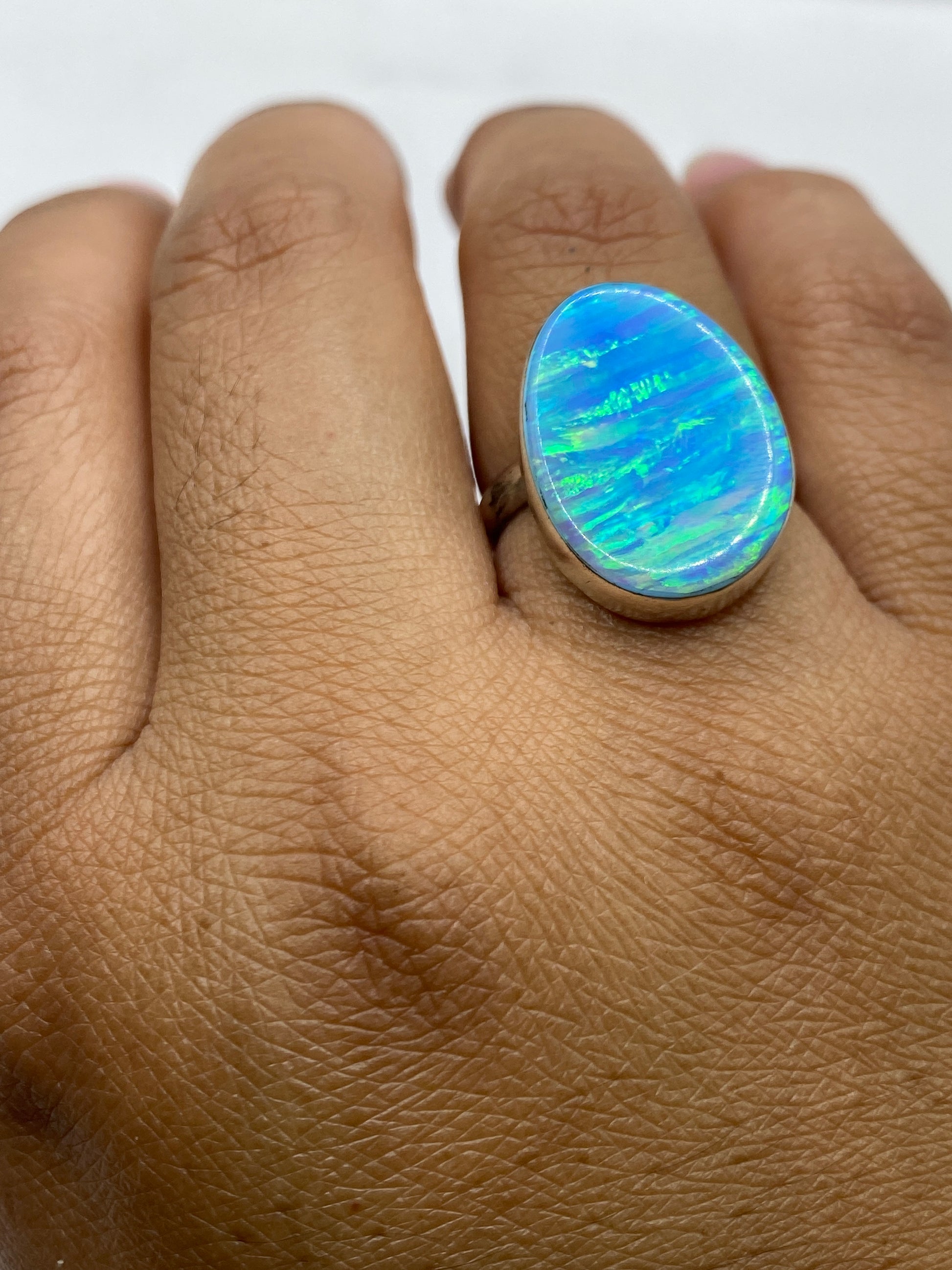 Anillo ópalo sobre fondo oscuro mostrando brillo natural del mineral