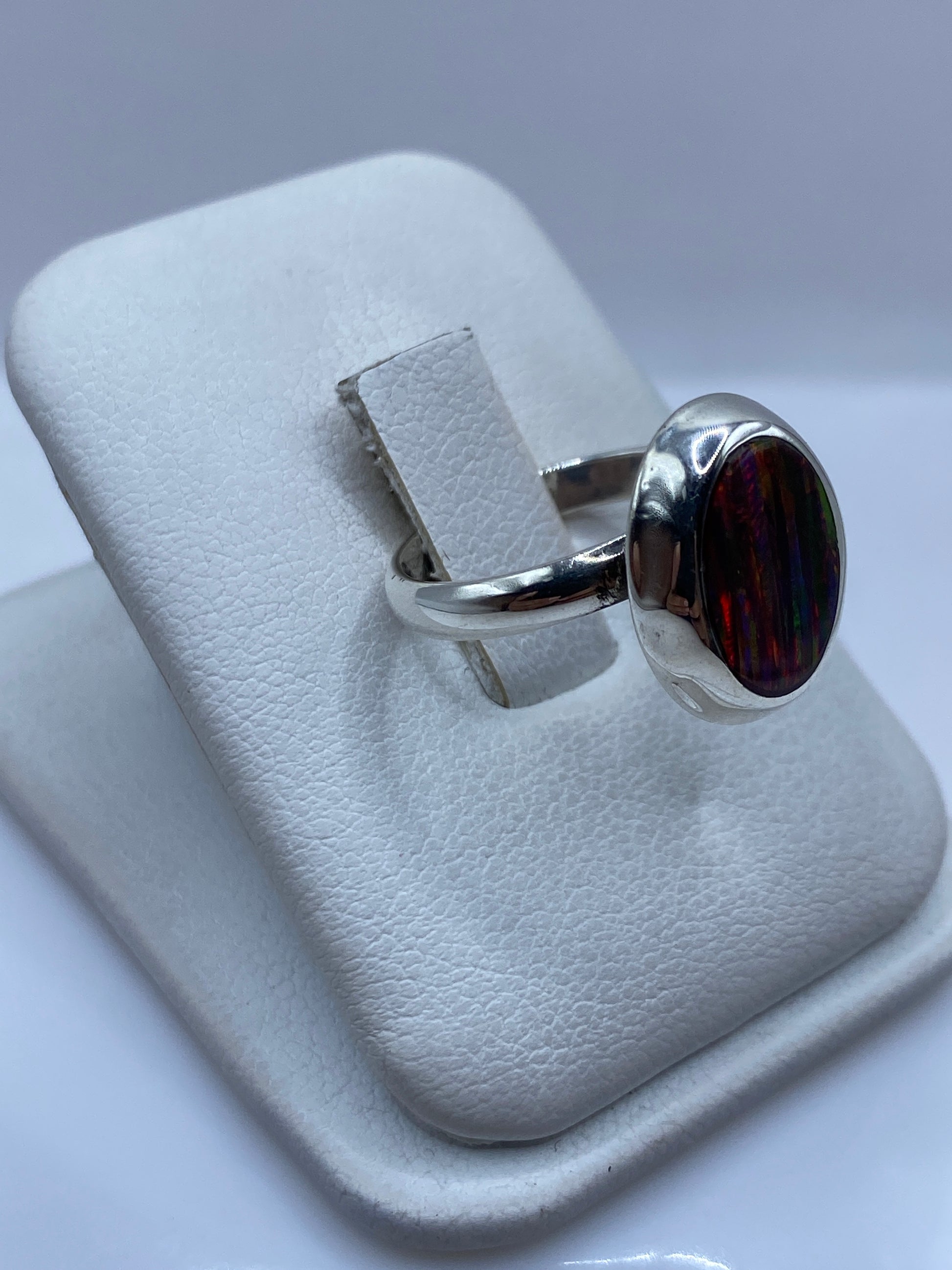 Detalle lateral del anillo solitario mostrando el juego de colores del ópalo