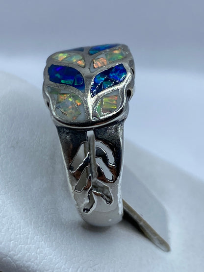 Vista lateral del anillo de ópalo multicolor mostrando la banda ornamentada de plata 950