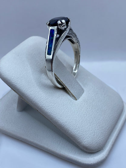 Vista frontal del anillo clásico con ópalo azul natural y banda texturada