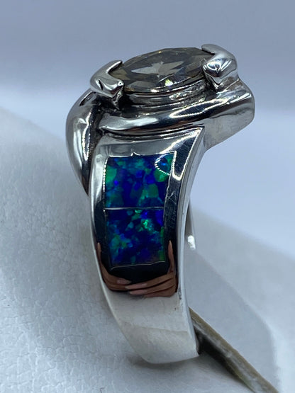 Anillo ópalo de fuego con detalles del juego de colores azul y verde, llevado en dedo