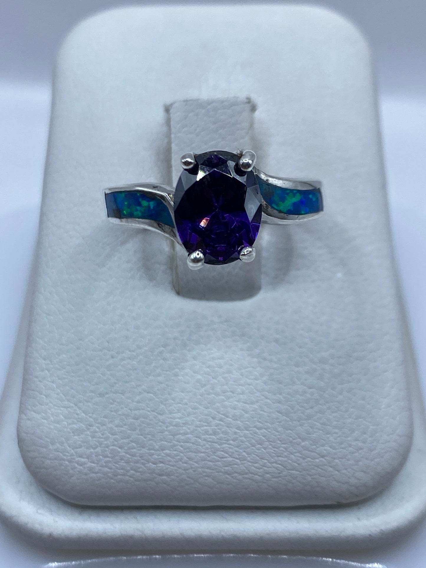 Anillo de plata con ópalo de fuego azul en la mano de una mujer
