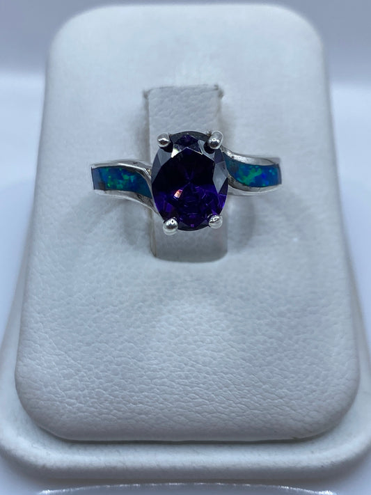 Anillo de plata con ópalo de fuego azul en la mano de una mujer