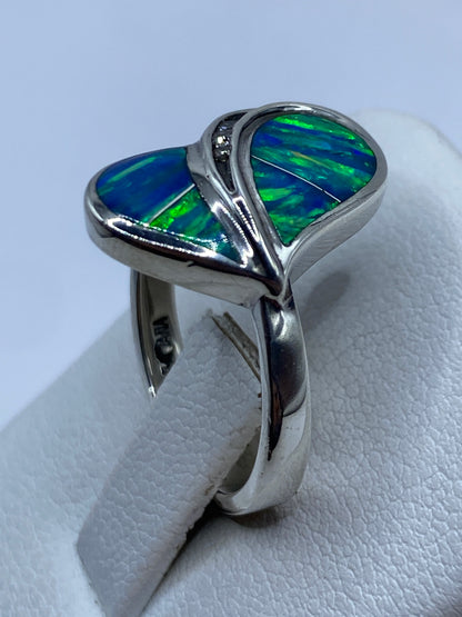 Anillo ópalo de fuego en la mano mostrando el juego dinámico de colores