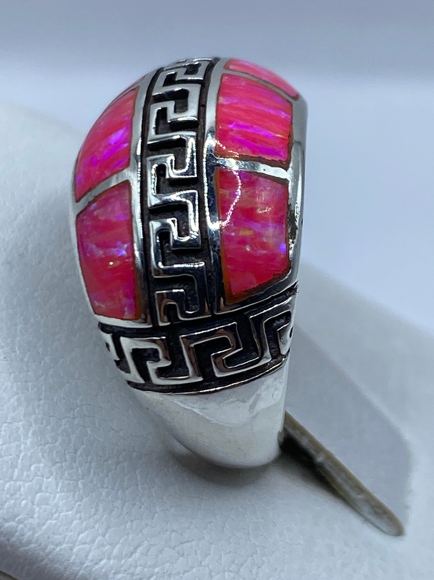 Anillo ópalo fuego en la mano de mujer mostrando el juego de colores naturales