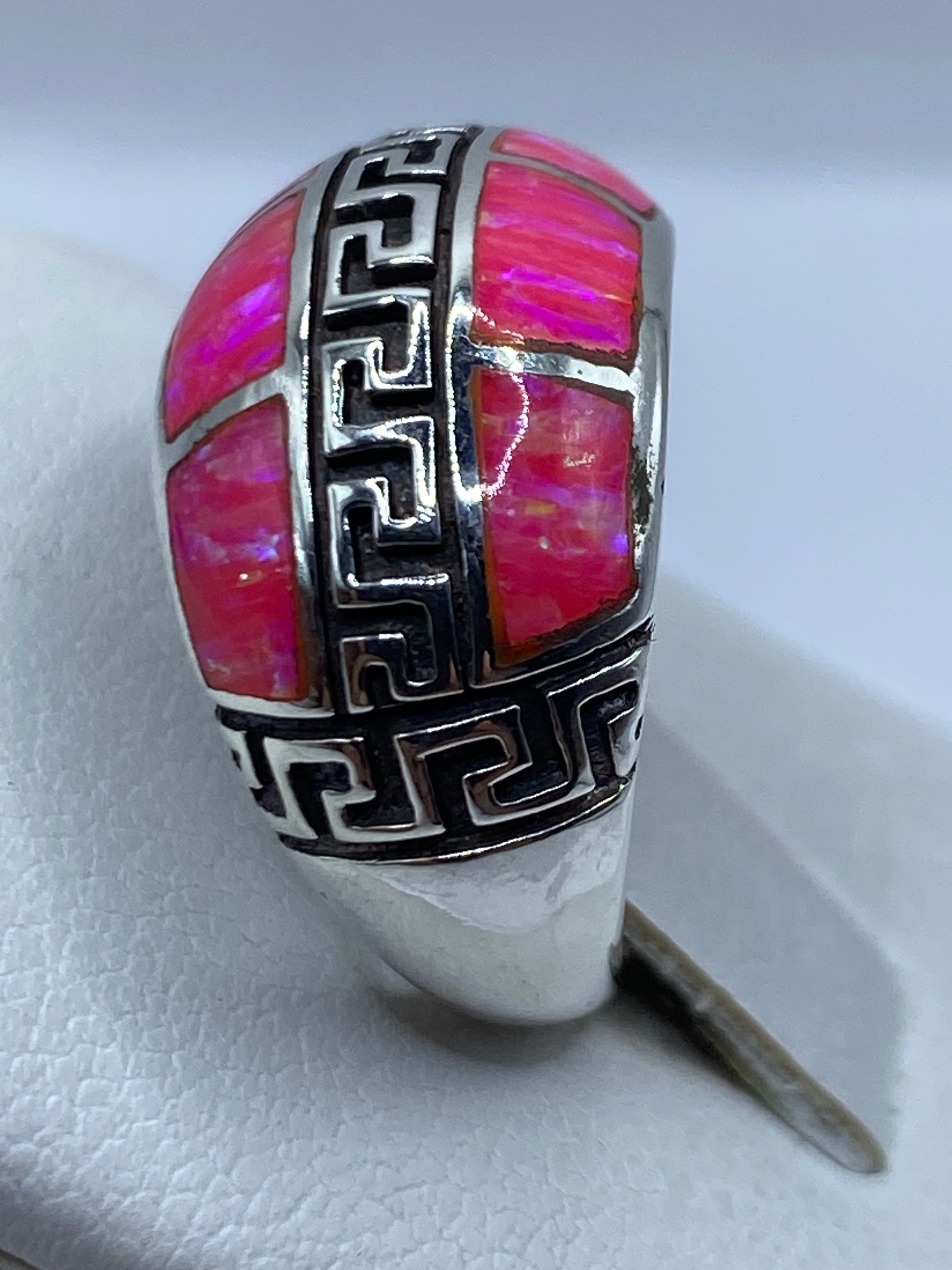 Anillo ópalo fuego en la mano de mujer mostrando el juego de colores naturales