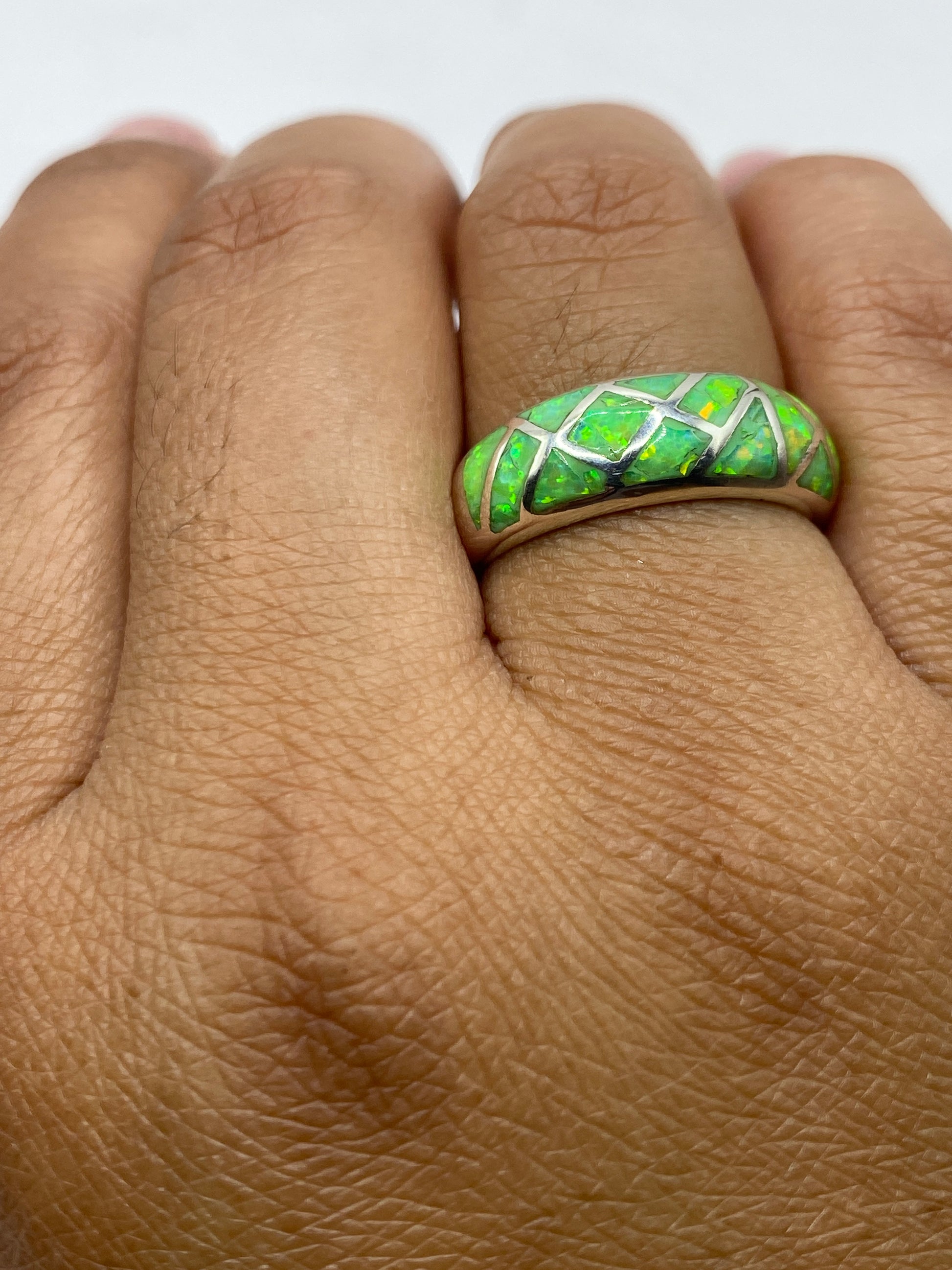 Anillo sobre dedo mostrando el color verde limón radiante del ópalo auténtico
