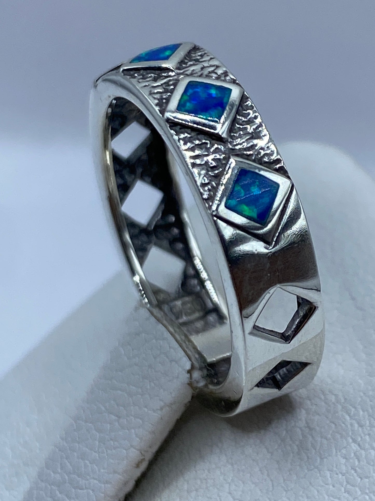 Anillo geométrico con textura martillada en mano, ópalo brillando