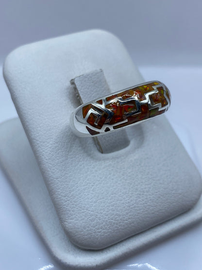 Detalle del ópalo de fuego naranja mostrando reflejos multicolores en el anillo