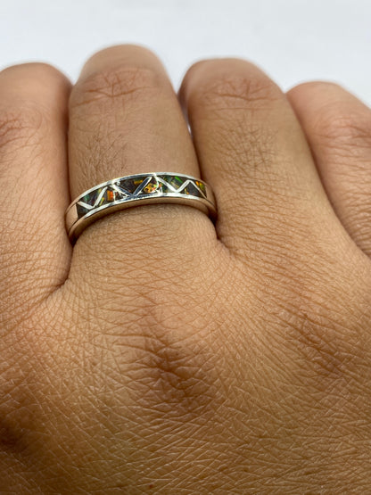 Anillo en mano mostrando ópalo natural con reflejos de fuego