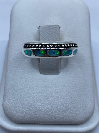 Anillo de plata con ópalo de fuego azul cielo y detalles perlados, visto de frente