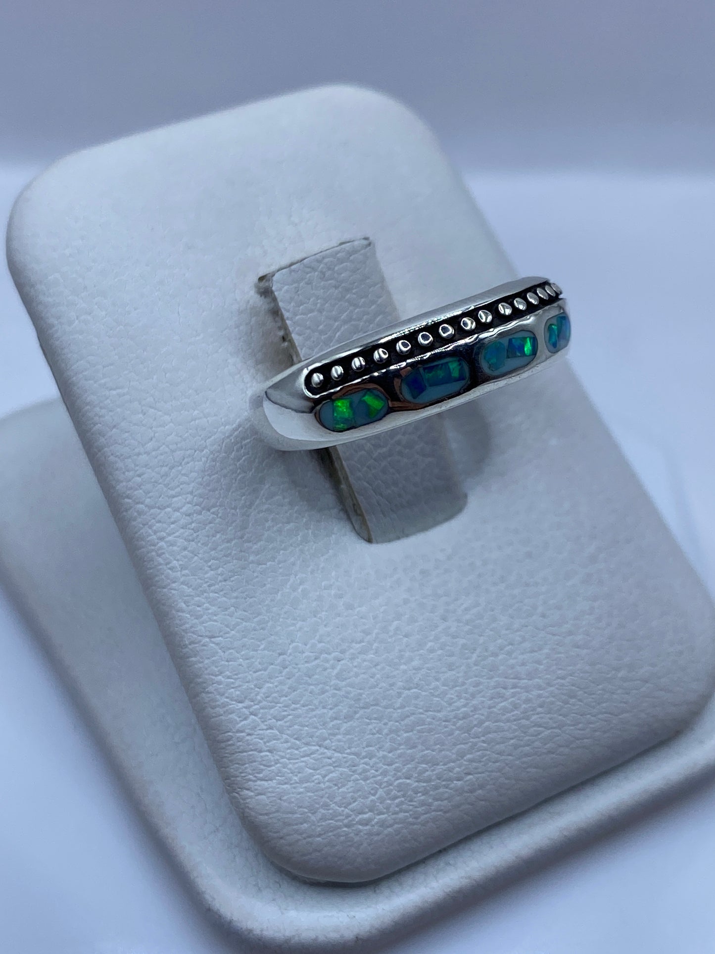 Anillo de plata .950 con ópalo natural en dedo, mostrando el juego de colores azul y verde