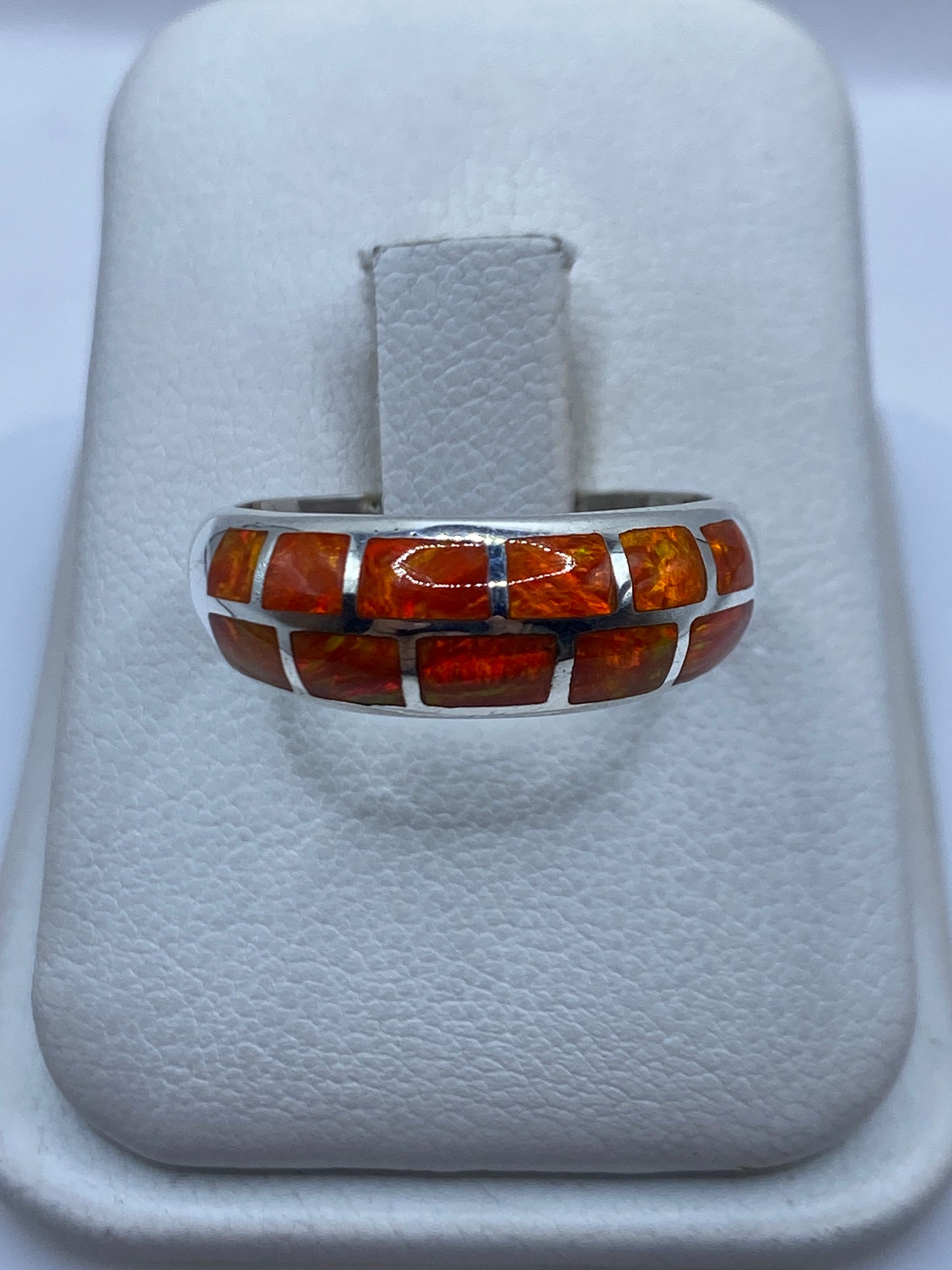 Anillo de plata .950 con ópalo de fuego naranja natural, vista frontal sobre anillo de presentación blanco