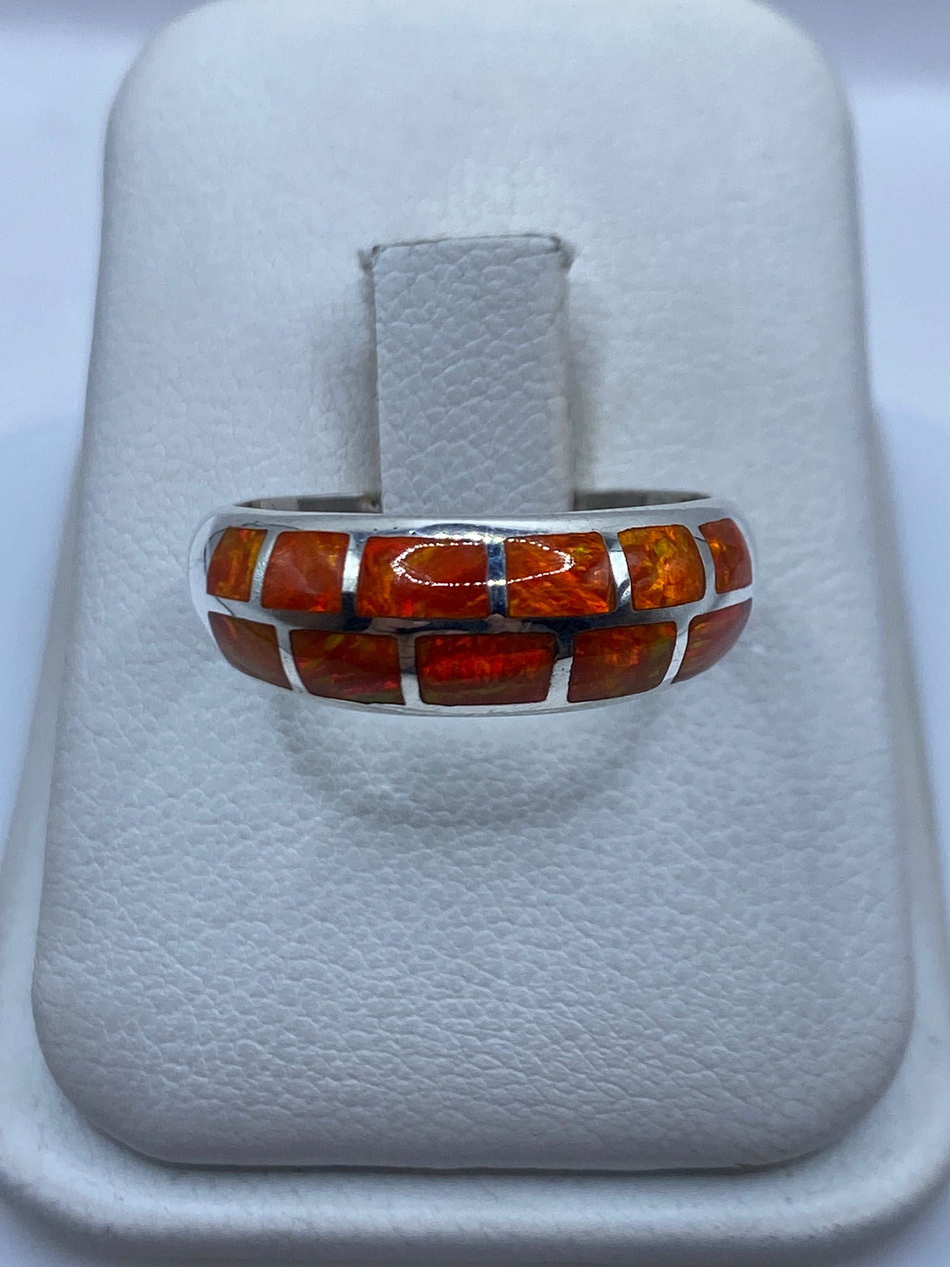 Anillo de plata .950 con ópalo de fuego naranja natural, vista frontal sobre anillo de presentación blanco