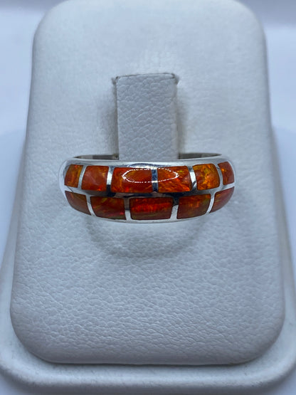 Anillo de plata .950 con ópalo de fuego naranja natural, vista frontal sobre anillo de presentación blanco