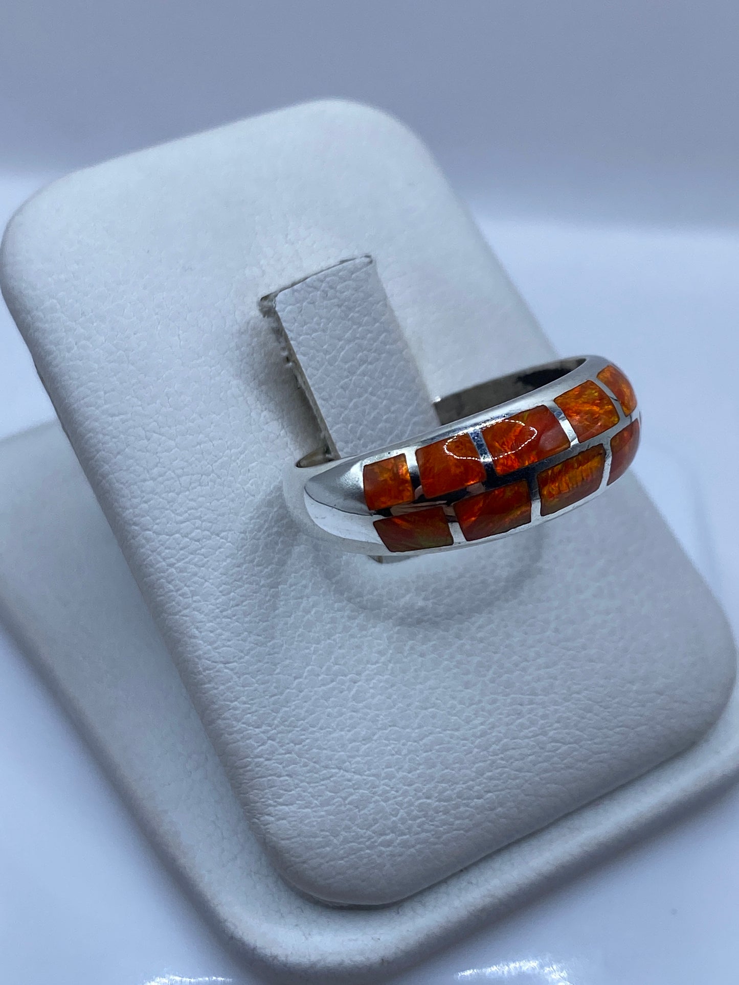 Detalle lateral del anillo mostrando el engaste y la pureza del color naranja del ópalo