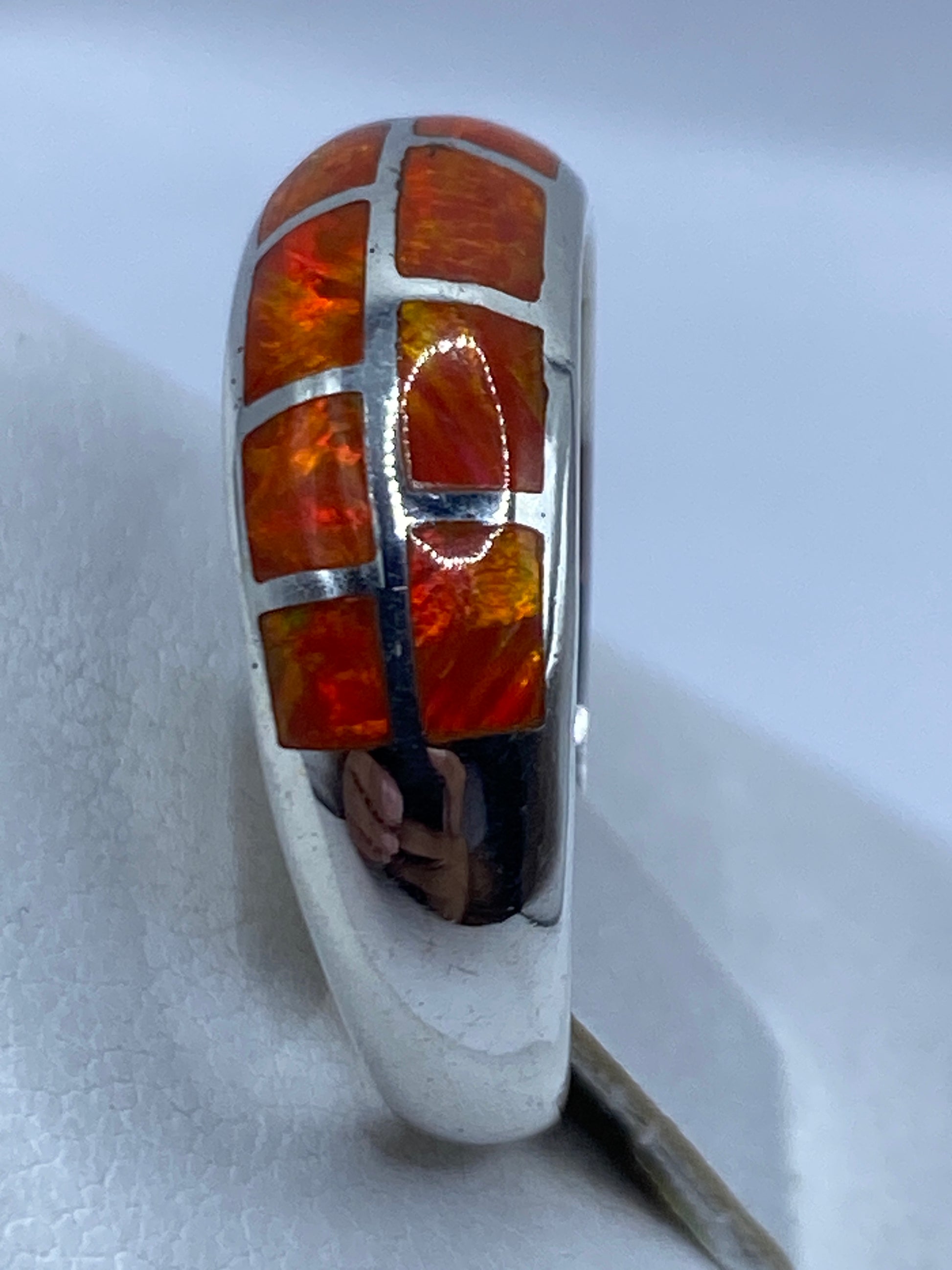 Anillo de ópalo naranja en dedo mostrando la luminosidad natural de la piedra