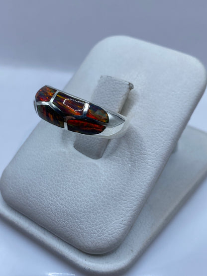 Detalle del ópalo de fuego en el anillo mostrando el juego de colores naturales