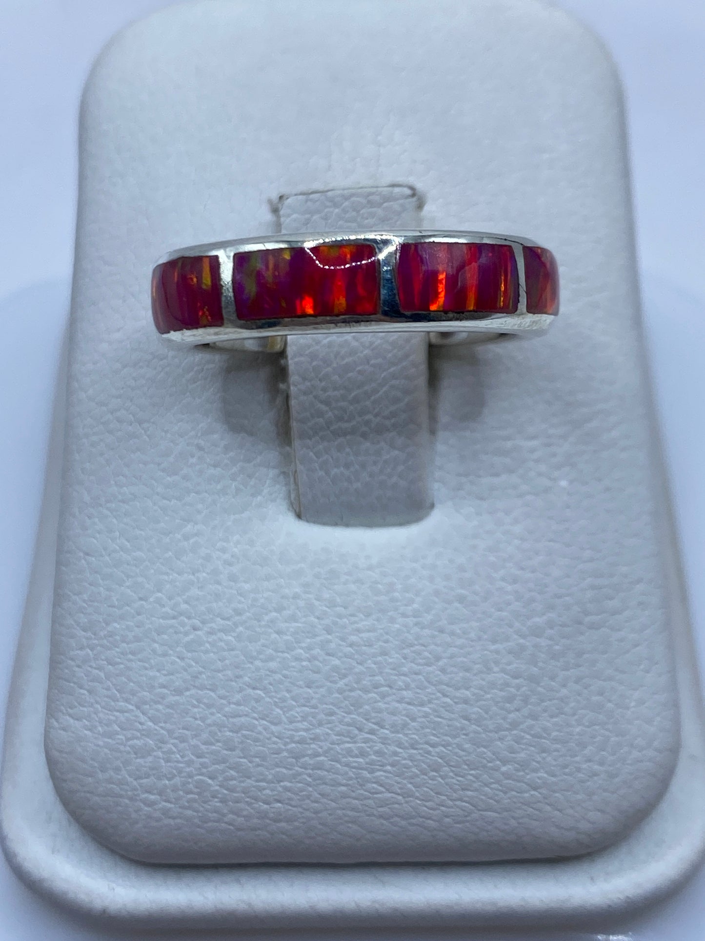 Anillo solitario de plata con ópalo de fuego rosa en joyero blanco