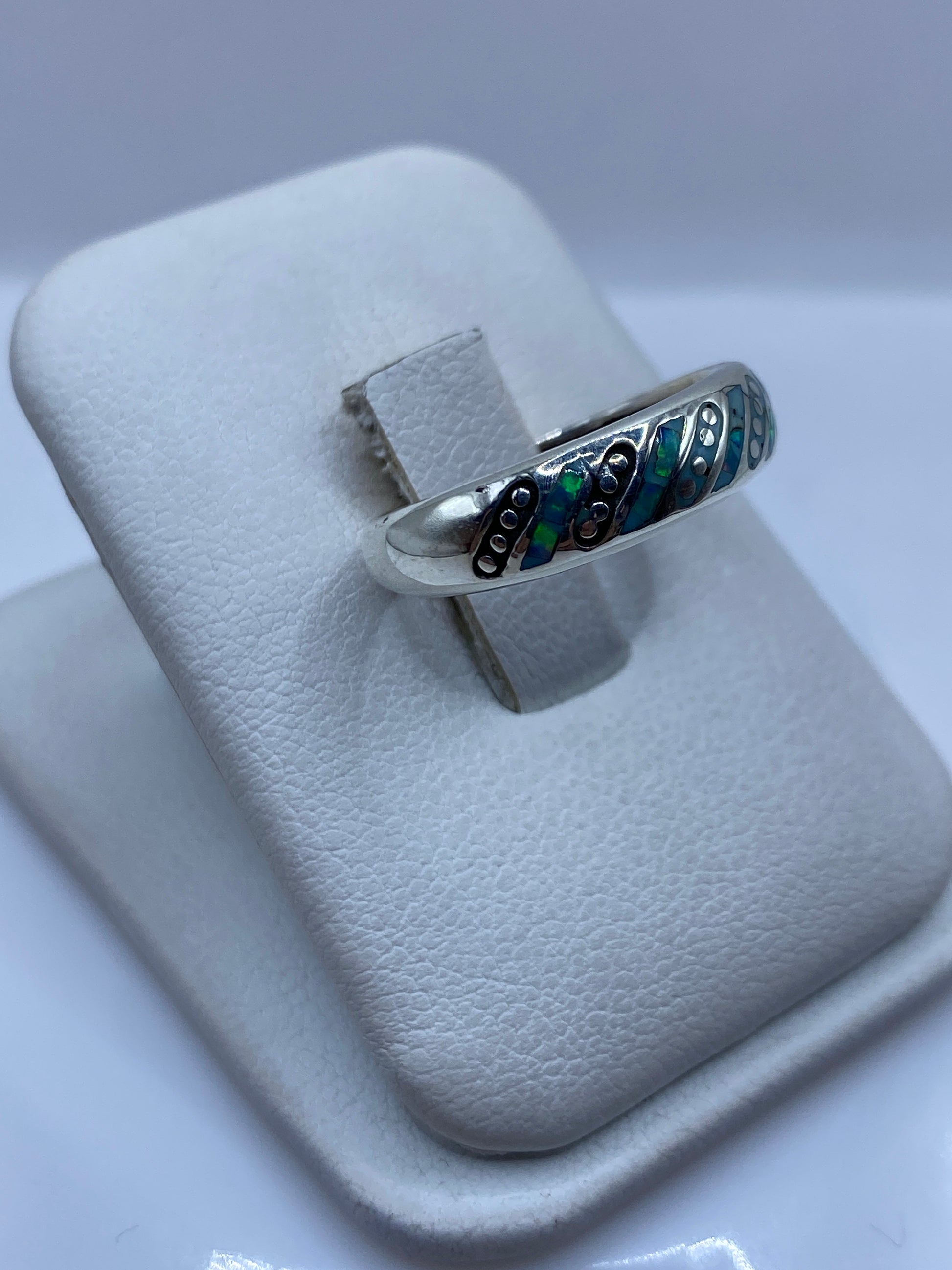 Vista lateral del anillo unisex mostrando el perfil y el fuego azul del ópalo natural