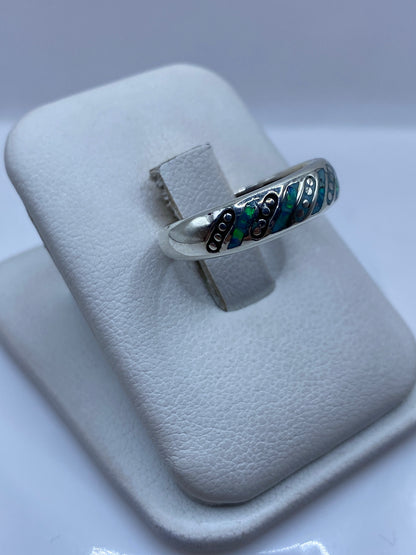 Vista lateral del anillo unisex mostrando el perfil y el fuego azul del ópalo natural
