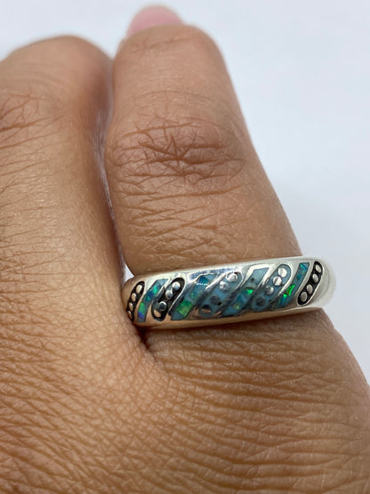 Anillo en dedo mostrando cómo el ópalo cambia de color según el movimiento, con sello 950 visible en el interior