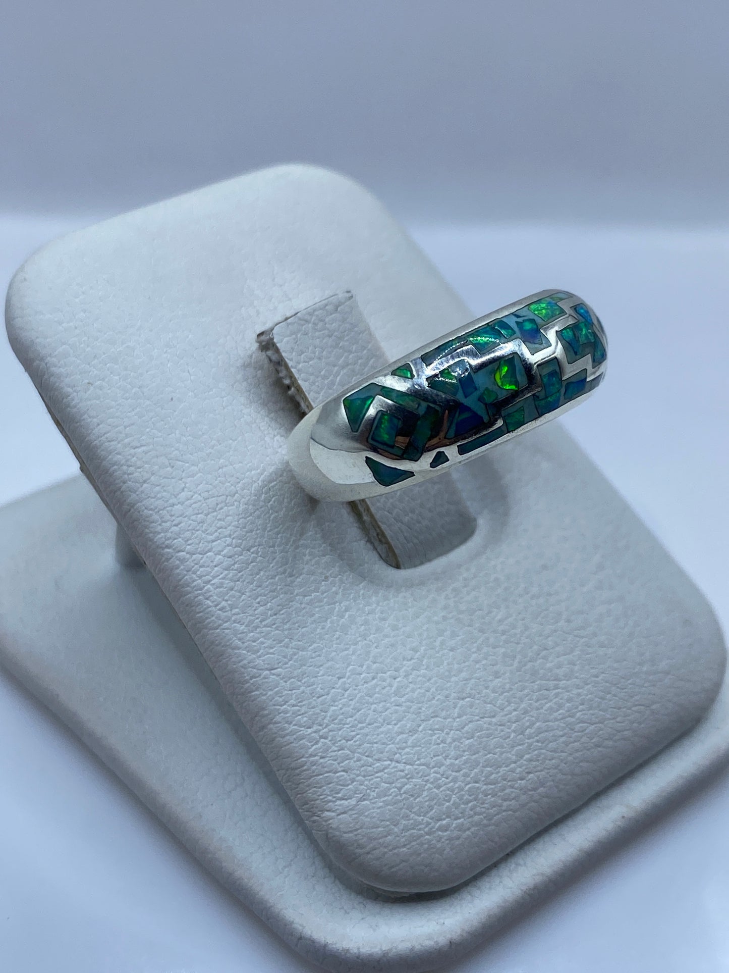 Vista lateral del anillo unisex mostrando el diseño asimétrico de líneas en plata