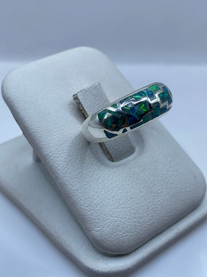 Vista lateral del anillo unisex mostrando el diseño asimétrico de líneas en plata