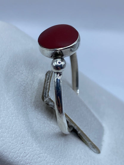 Detalle del frente del anillo platero con piedra roja engastada en plata
