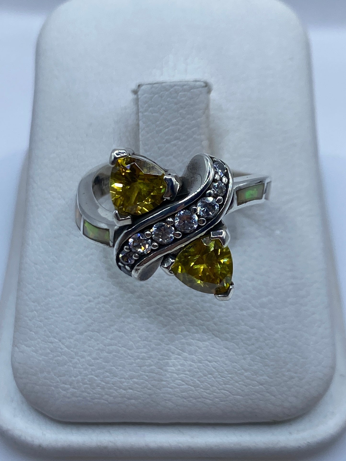 Anillo de plata circonia amarilla asimétrico en mano de mujer, mostrando brillo y facetas