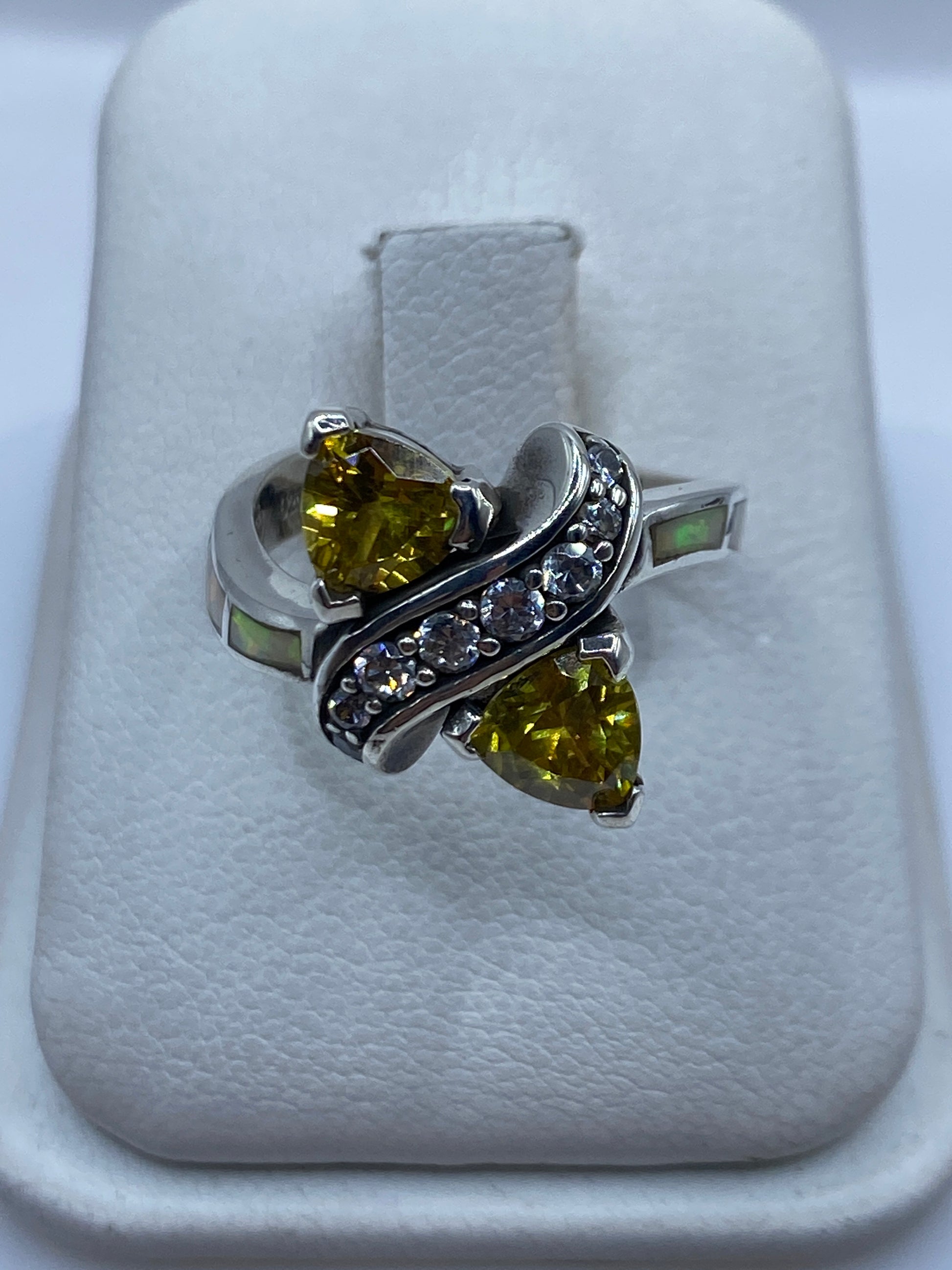 Anillo de plata circonia amarilla asimétrico en mano de mujer, mostrando brillo y facetas
