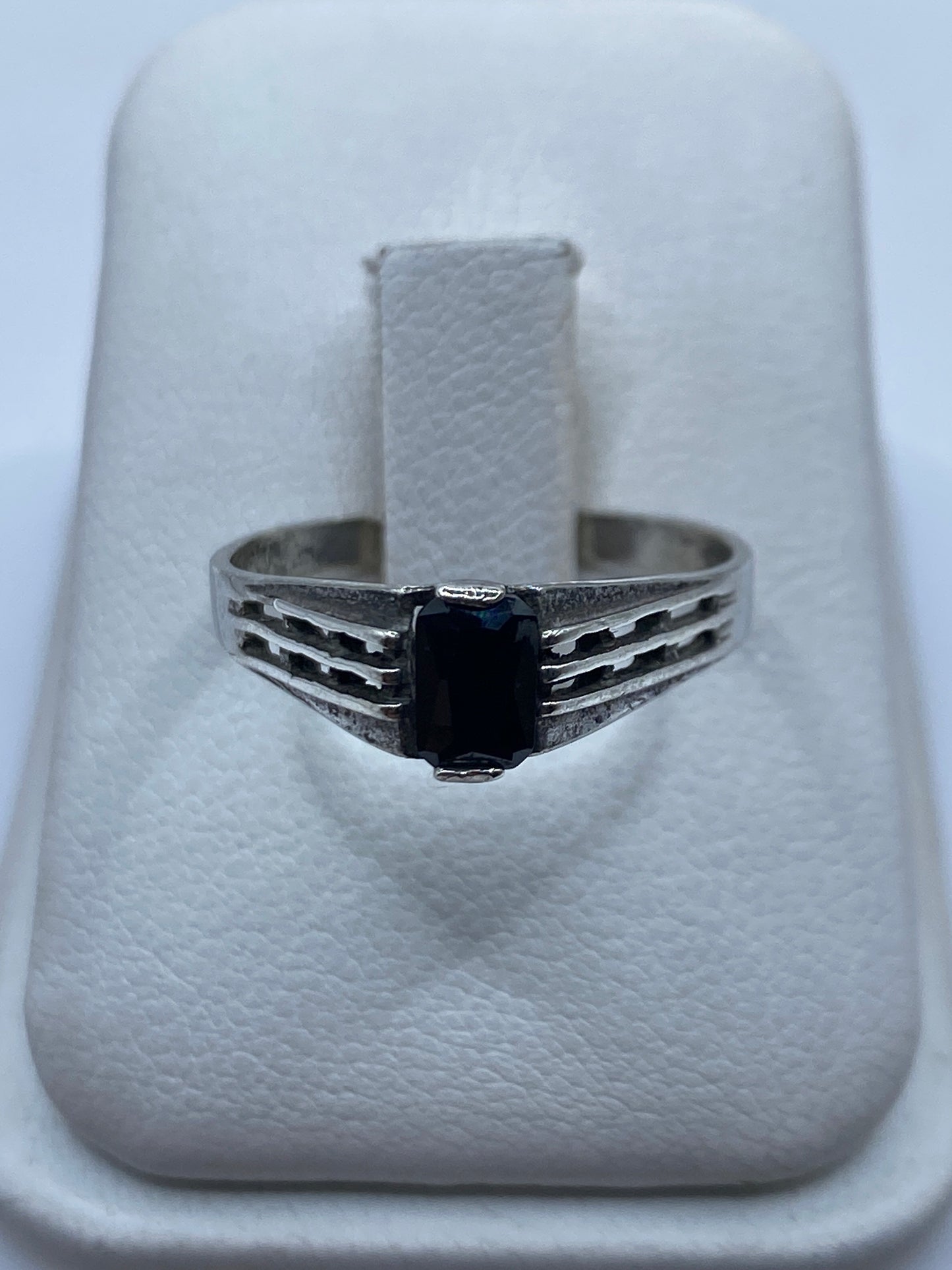 Anillo de plata solitario con circonia negra brillante sobre banda engravada, vista frontal