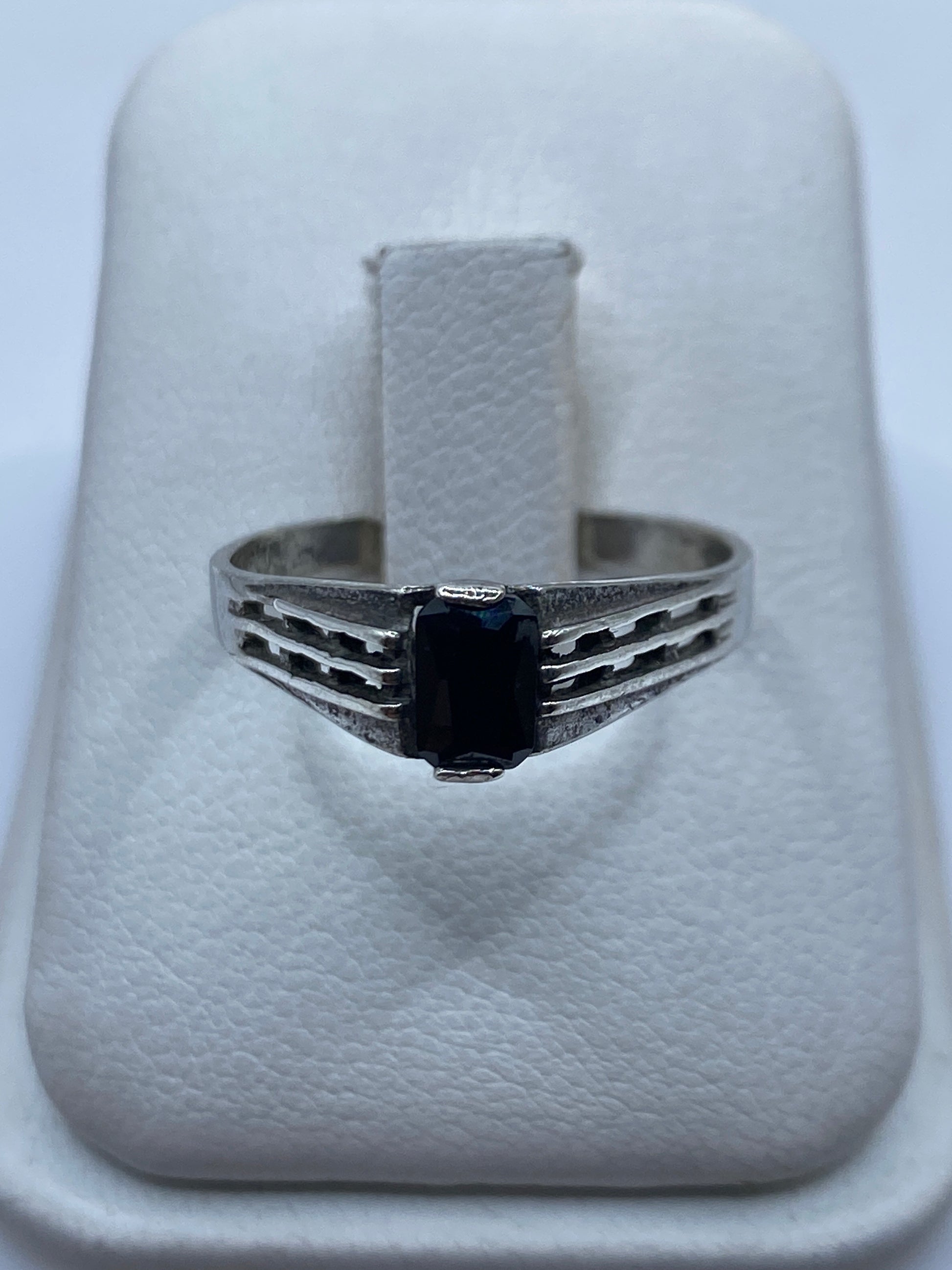 Anillo de plata solitario con circonia negra brillante sobre banda engravada, vista frontal