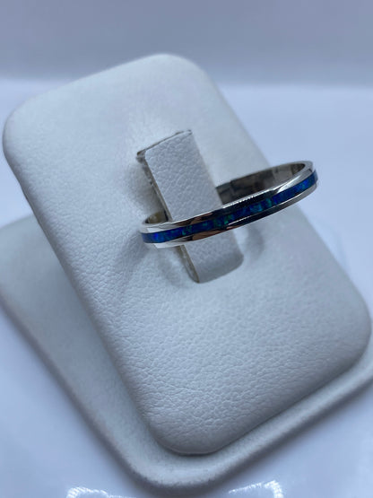 Ópalo de fuego azul mostrando juego de colores en anillo de plata minimalista