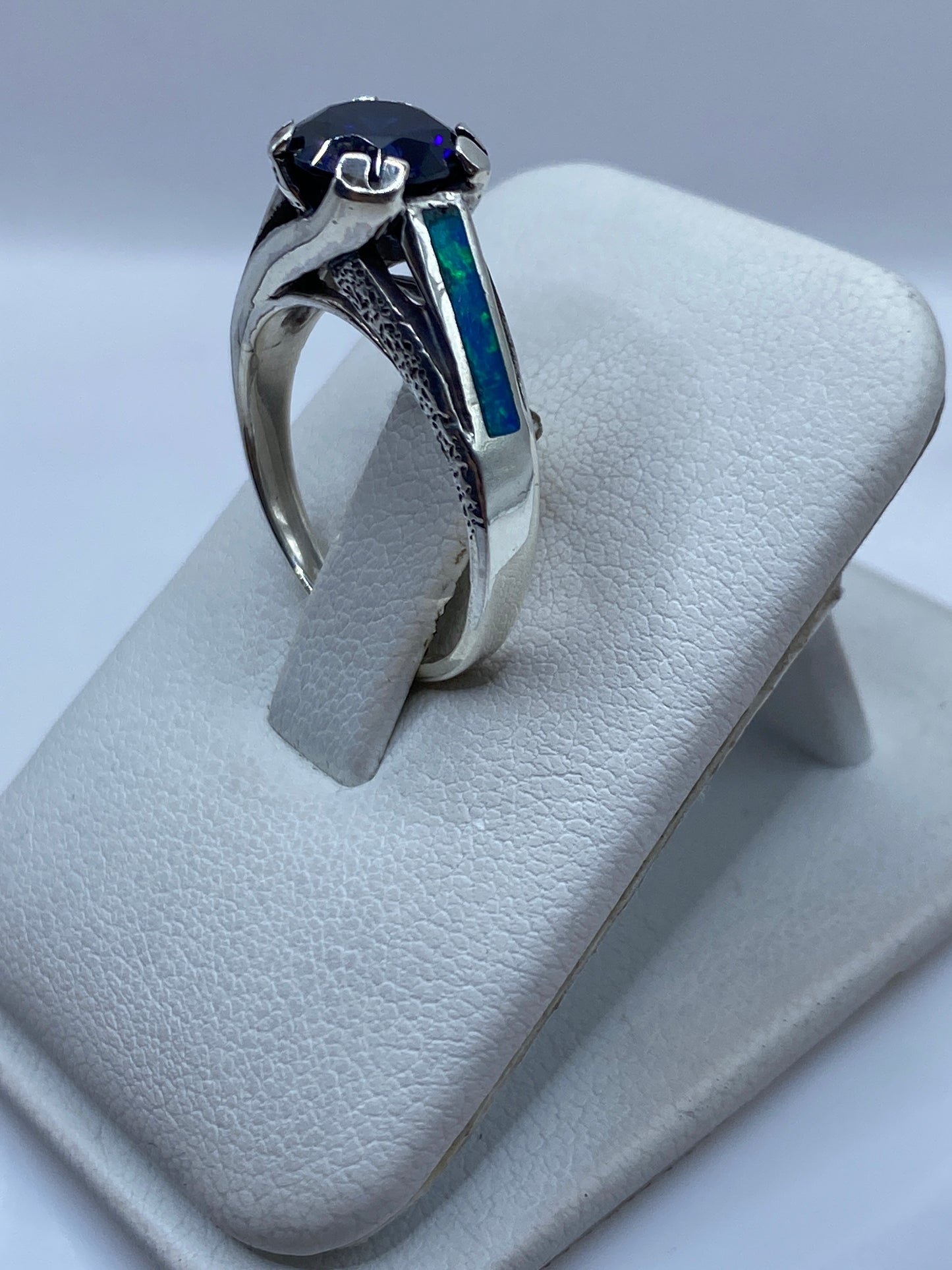 Detalle del ópalo azul con reflejos verdes engastado en plata .950, vista frontal