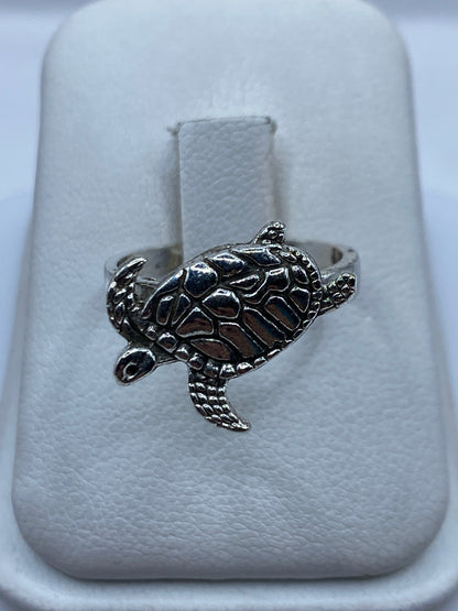 Anillo de plata con tortuga marina en relieve, talla 7, sobre estuche de joyería
