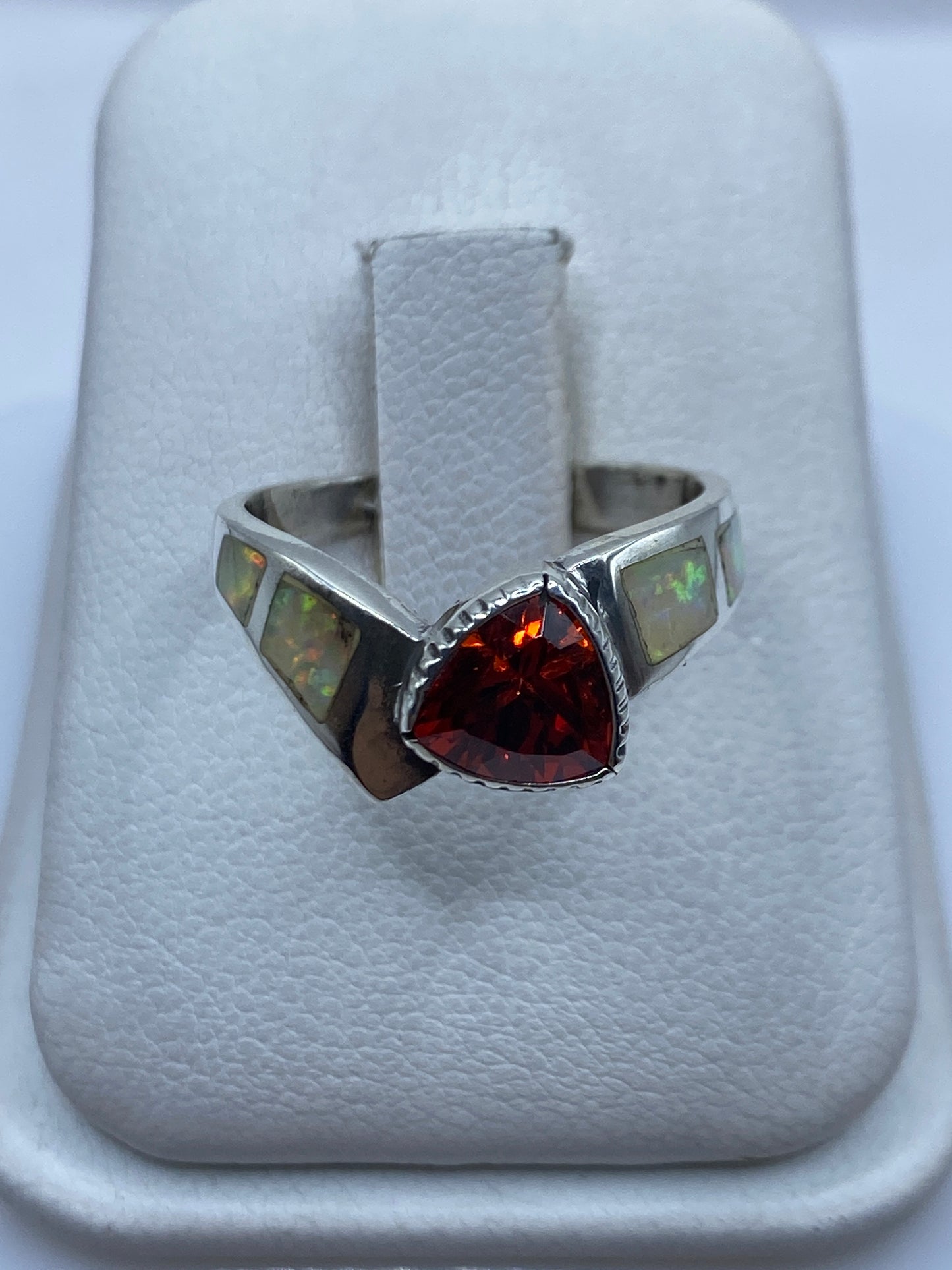 Anillo de plata solitario con ópalo de fuego en la mano de una mujer