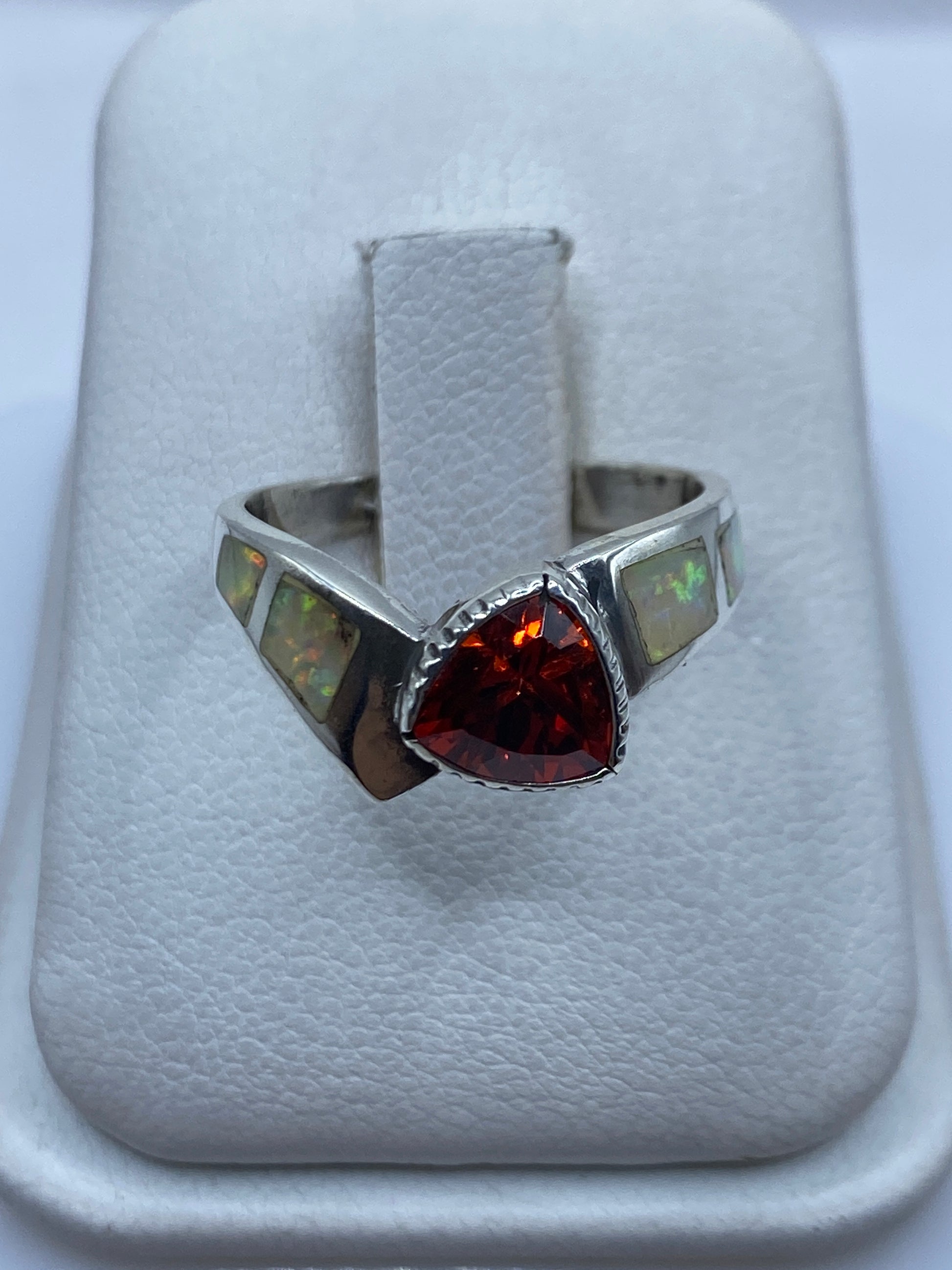 Anillo de plata solitario con ópalo de fuego en la mano de una mujer