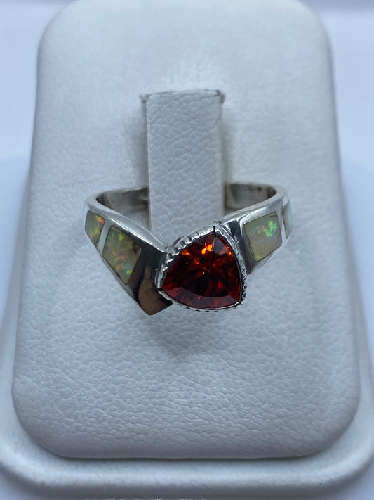 Anillo de plata solitario con ópalo de fuego en la mano de una mujer