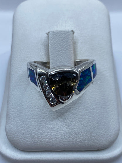 Anillo de plata coctel con Ópalo de Fuego azul y Lapislázuli en la mano de una mujer