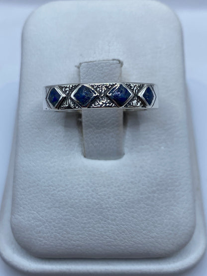 Anillo de plata con lapislázuli azul profundo y vetas doradas en la mano de una persona