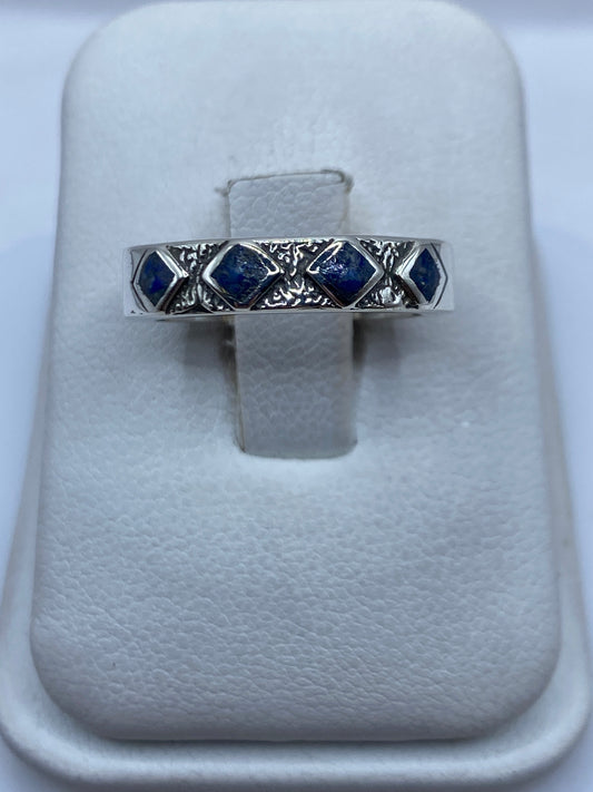 Anillo de plata con lapislázuli azul profundo y vetas doradas en la mano de una persona
