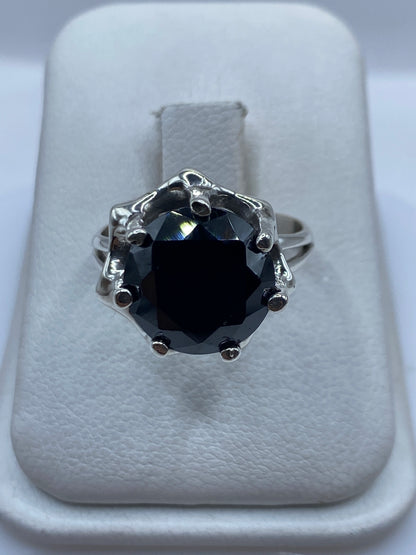 Anillo solitario de plata .925 con circonia negra facetada, sobre cojinete blanco