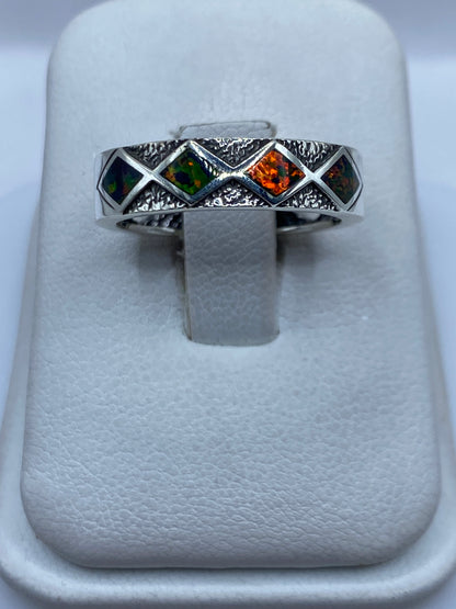 Anillo de plata con ópalo de fuego multicolor sobre soporte blanco