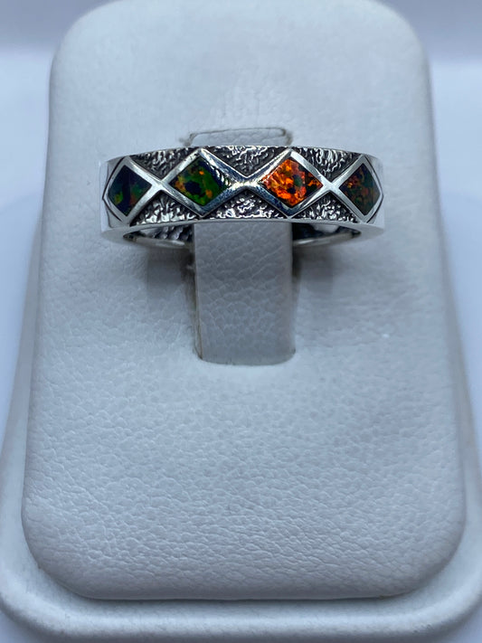 Anillo de plata con ópalo de fuego multicolor sobre soporte blanco