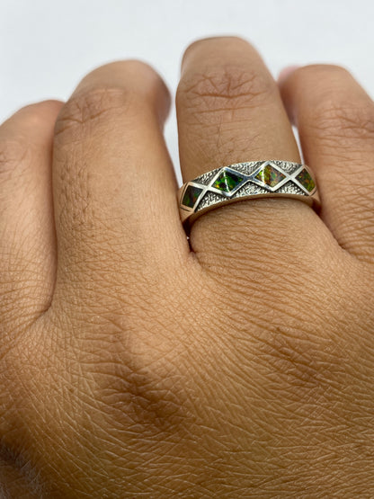 Anillo llevado en dedo, ópalo brillante bajo luz natural